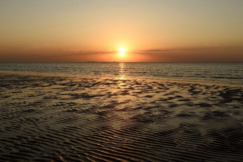 Sunset over the Wadden Sea on the German North Sea coast, typical ripple mudflats at low tide,