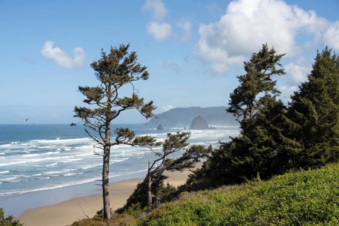 Sunny beach with large rocks in the sea and clear blue sky, peaceful and relaxing atmosphere,
