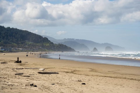 Sunny beach with large rocks in the sea and clear blue sky, peaceful and relaxing atmosphere,