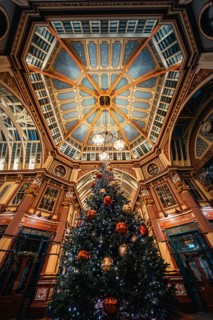 Festive Christmas decoration with large tree under impressive ceiling in an interior, London,