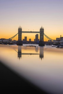 Famous bridge at sunset with reflection in the river and skyline in the background, London, United