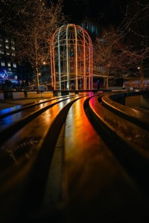 Night scene with colorful illuminated pavilion and twinkling lights in an urban setting, London,