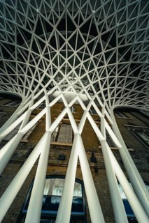 Futuristic geometric ceiling pattern with white pillars in modern architecture, King's Cross