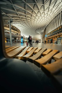 Modern station concourse with eye-catching ceiling patterns and people in a lively atmosphere,