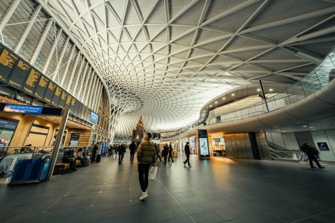Bright and spacious train station with modern glass architecture and busy travelers, King's Cross