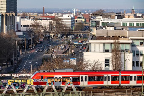 S-Bahn train on the line, railway bridge over Deutz-Mülheimer-Straße, platform tracks in front of