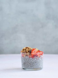 Chia seed pudding layered with fresh strawberries and crunchy granola in a glass