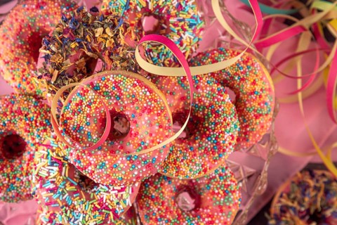 Colourful donuts and streamers on a pink towel, Mardi Gras