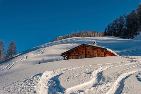 Upper Priesbergalm surrounded by deep snow with ski tracks, Berchtesgaden Alps, Berchtesgaden