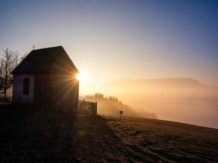 Sunbeams at a chapel above high fog at sunrise, Untersberg in the background, Högl, Anger,