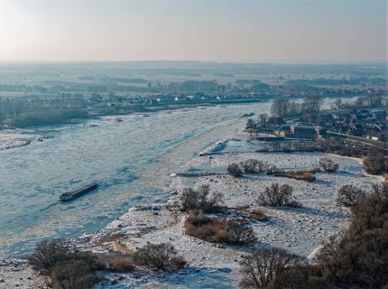 On a cold winter day, a barge sails downstream on the Elbe near Hamburg when there is slight ice.
