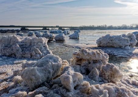 Ice skating on the Elbe with small icebergs on the water and on the banks of the Elbe Island near