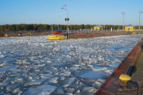 Icy water area at a lock with yellow buoys under clear blue sky, ice floes, Hohenwarthe lock,