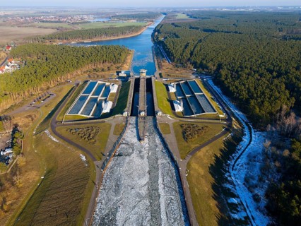Aerial view of a lock surrounded by forests, surrounded by ice-covered waterways, aerial view,