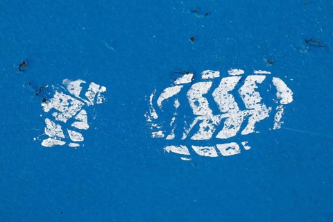 White paint imprint of a shoe sole on a blue painted surface