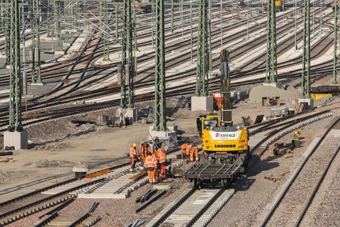 Team of workers works on rails using construction machinery at a large plant, Untertürkheim parking