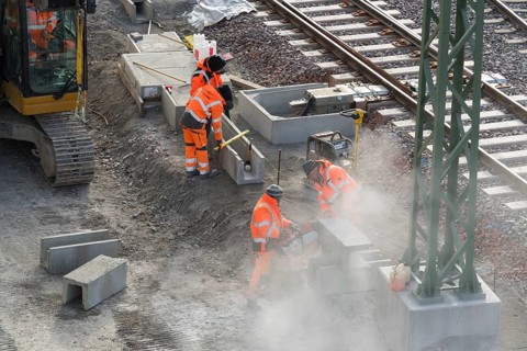 Workers on a construction site use machines to process rail sections, Untertürkheim parking