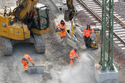 Construction workers use construction machinery to lay rail structures, cutters, vibrators,