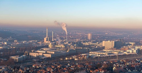 Extensive city view at sunrise with industrial plants and smoke developments, view of Daimler Group