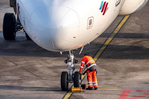 Ground crew positions brake blocks on the chassis, after stopping at the parking position, at the