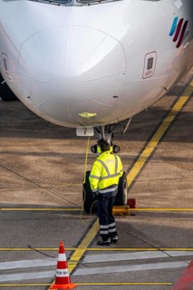 Ground crew talking about intercom with the cockpit, after stopping at the parking position, at the
