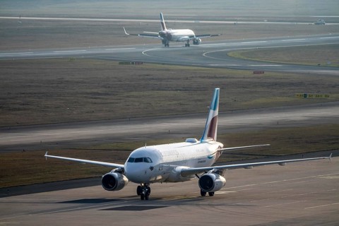 Eurowings Airbus after landing on the taxiway to the terminal, plane taking off, to Cologne/Bonn
