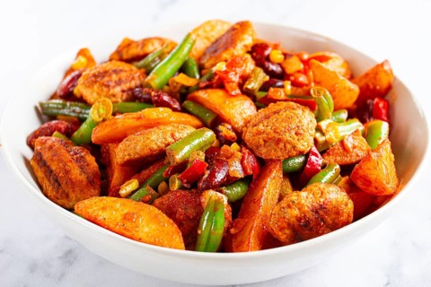 Steakhouse pfanne, fried potato slices, with meatballs, and vegetable mixture, on a white plate