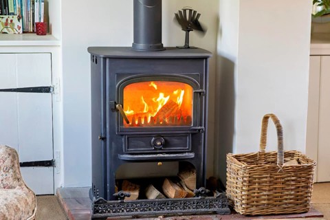 Logs burning in roaring fire of Clearview stove in domestic residential living room, UK