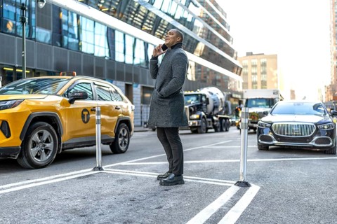 Businessman standing on a bustling manhattan street, having an important conversation on his mobile