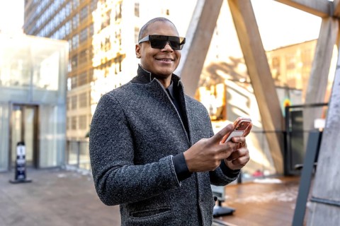 Businessman in modern sunglasses looking at new horizons while standing in a busy urban setting,