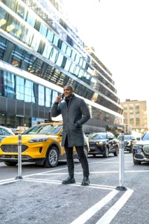 Professional man having a mobile phone conversation on a city street, standing confidently amidst
