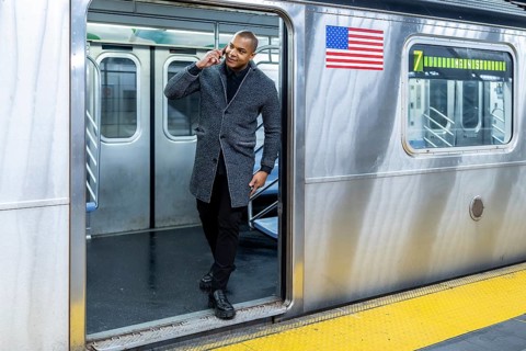 Professional man talking on a mobile phone exiting a subway train at a station platform in new york