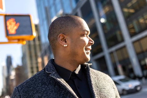 Professional man confidently walking through the vibrant city streets, looking ahead with a happy