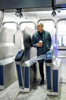 Professional man entering a modern subway station, confidently navigating the turnstile system