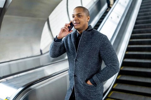 Young businessman talking on his smartphone while traveling on an escalator in a manhattan subway