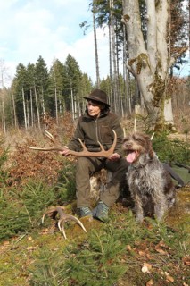Huntress with a deer (Cervus elaphus) hunting dog Griffon at her side, Allgäu, Bavaria, Germany,