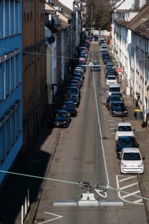 View from above of a street with parked cars and residential buildings with apartment buildings in