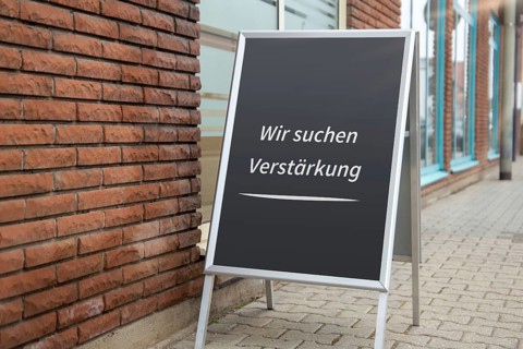 (photo montage) Display with the inscription WE ARE LOOKING FOR REINFORCEMENT in front of a shop
