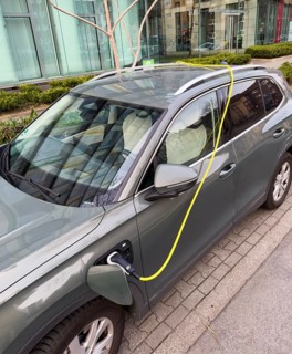 An e-car is charged at a charging station in Düsseldorf, the charging cable is stored over the roof