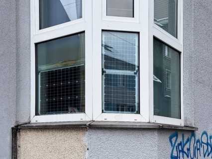 Window front, bay window with solar panels used, sustainable and unusual energy generation in