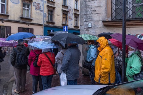 Travel group in the rain in front of the hotel, Krakow, Poland