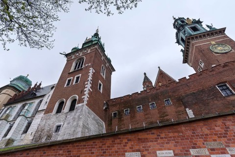 North façade of the cathedral on Wavelhügel, tourist group in the rain, Krakow, Poland