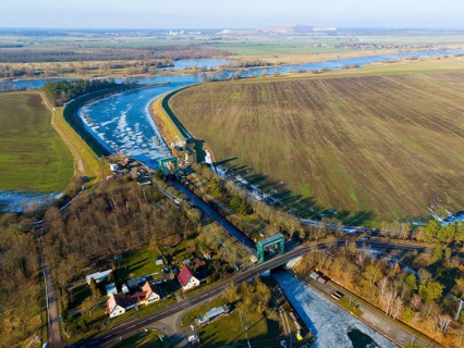Lock surrounded by fields and a river curve, with an adjacent village, aerial view, Niegripp lock,