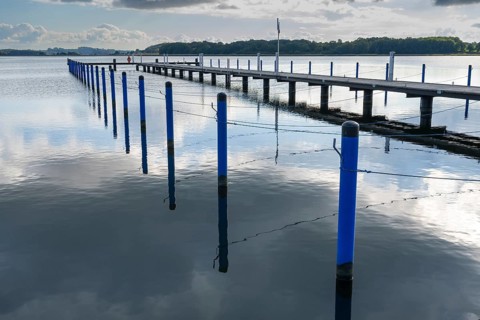 Piles with ropes for mooring for boats, boat dock, graphic effect, Sellin harbour, Sellin lake,
