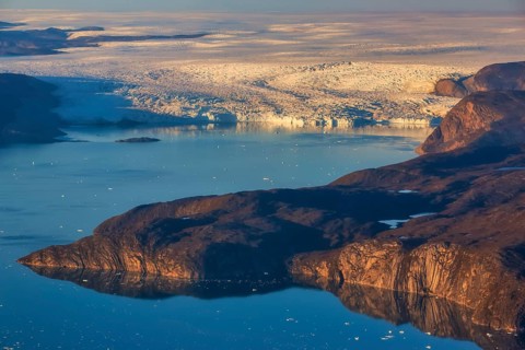 Aerial view of coast and Greenland ice sheet, Arctic landscape, frozen wilderness, glaciers and