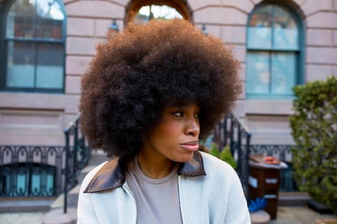 African american woman with a large afro hairstyle looking away, wearing a casual jacket, standing