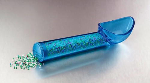 Blue, transparent ice cream scoop filled with coloured sugar sprinkles