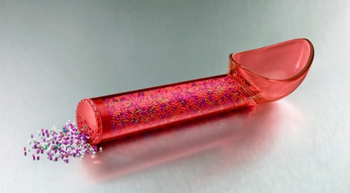 Red, transparent ice cream scoop filled with coloured sugar sprinkles
