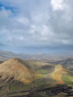 View of Montaña Tesa volcano from Montaña Blanca mountain with cloudy sky, Lanzarote, Canary