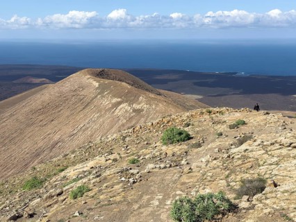 View from Caldera Blanca volcano against blue sky with white clouds, Mancha Blanca, Lanzarote,